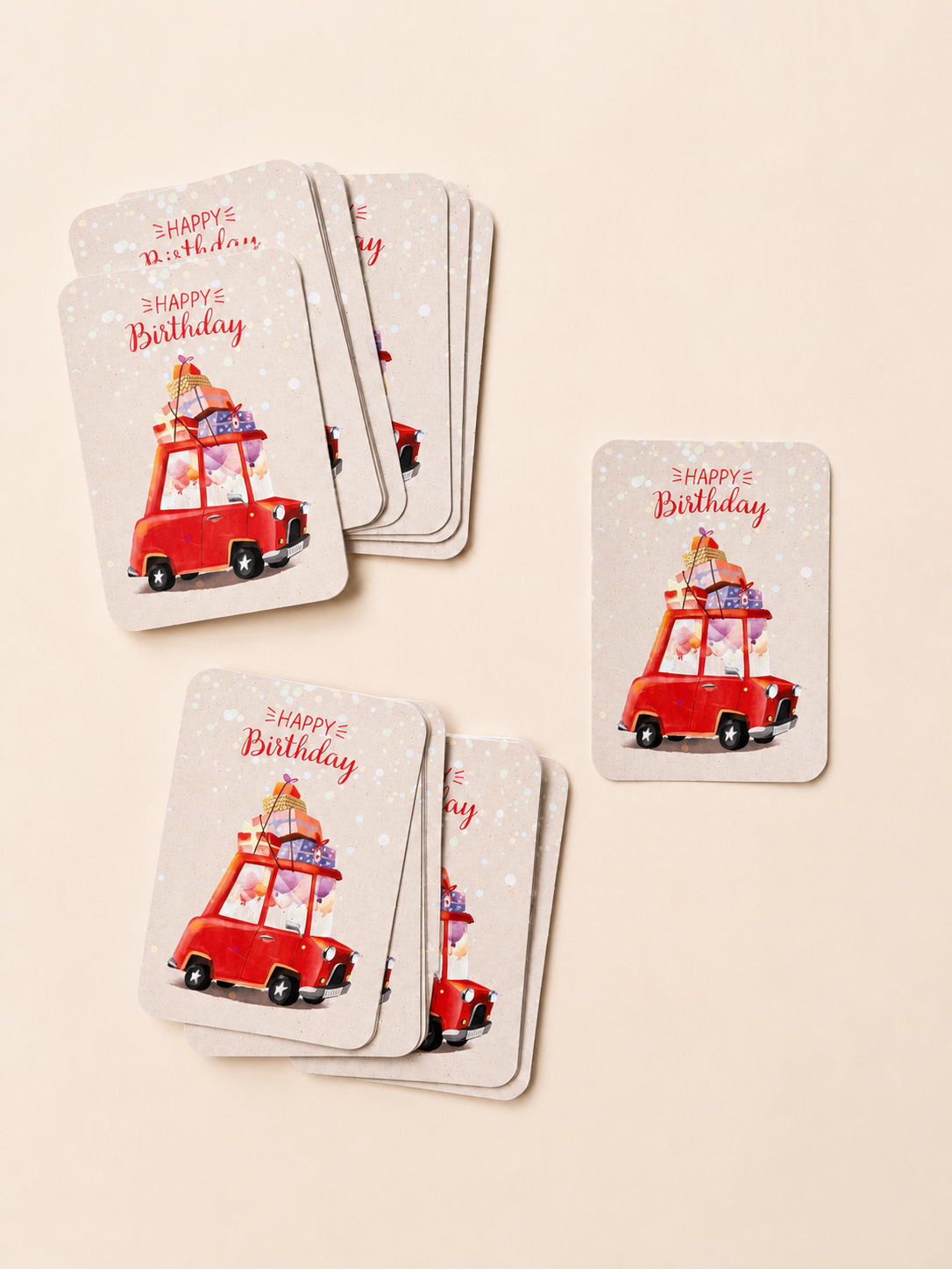 Happy Birthday cards arranged on a light neutral background, featuring a red car loaded with colourful gifts