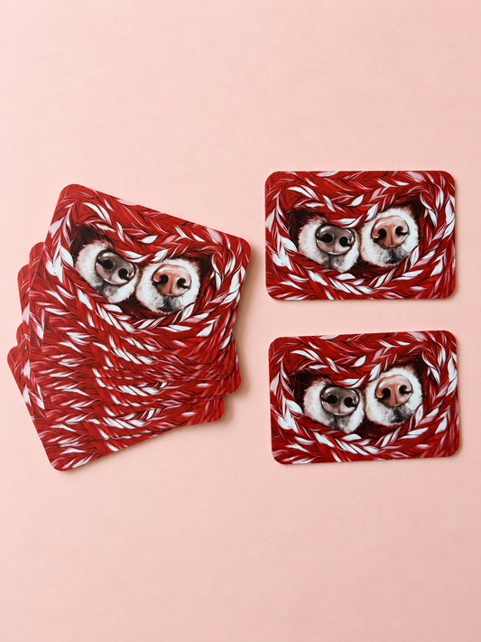 Mini cards featuring two dogs wrapped in a red-and-white knitted blanket, arranged on a soft powder pink background
