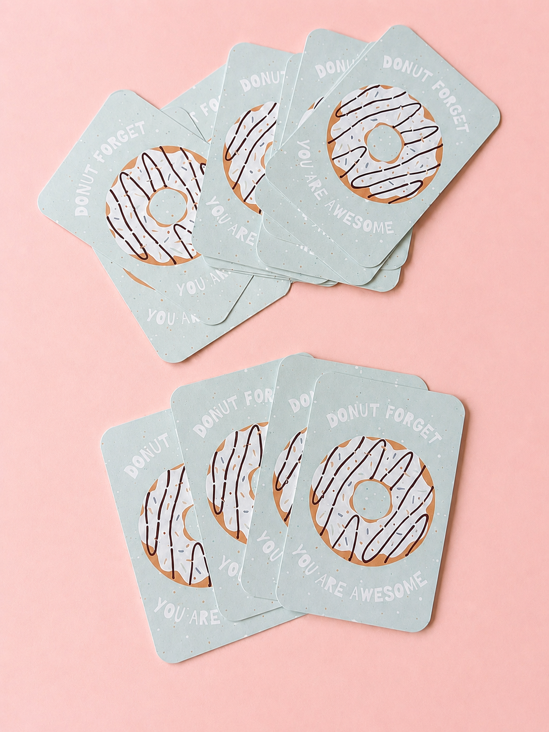 Donut-themed mini cards with the message “Donut Forget You Are Awesome,” arranged in two overlapping stacks on a soft powder pink background