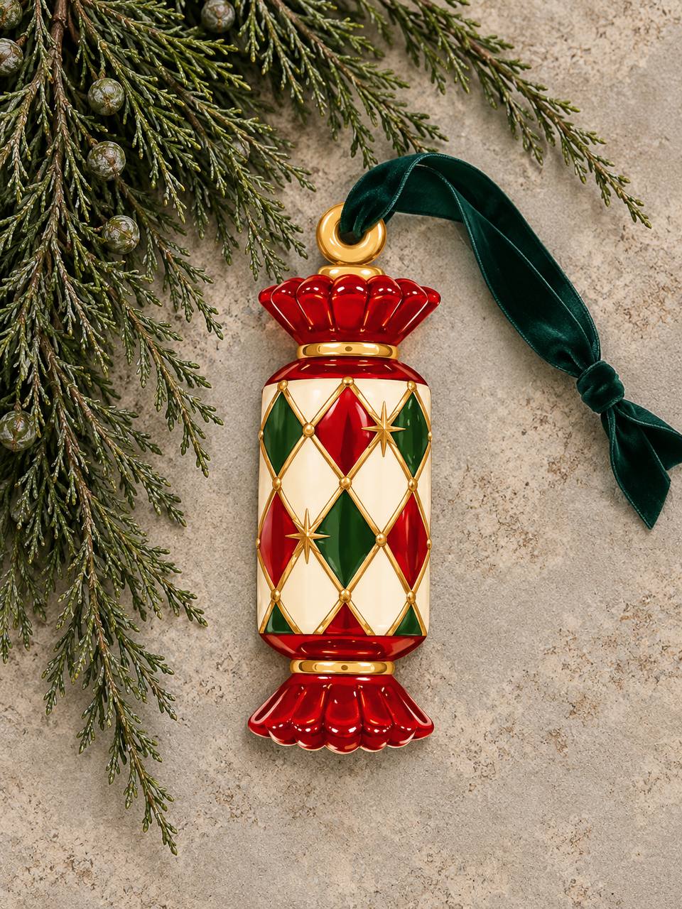 Shaped paper ornament "Circus Candy" with an embossed red, green, and gold jeweled pattern, hung with a green ribbon among pine branches.